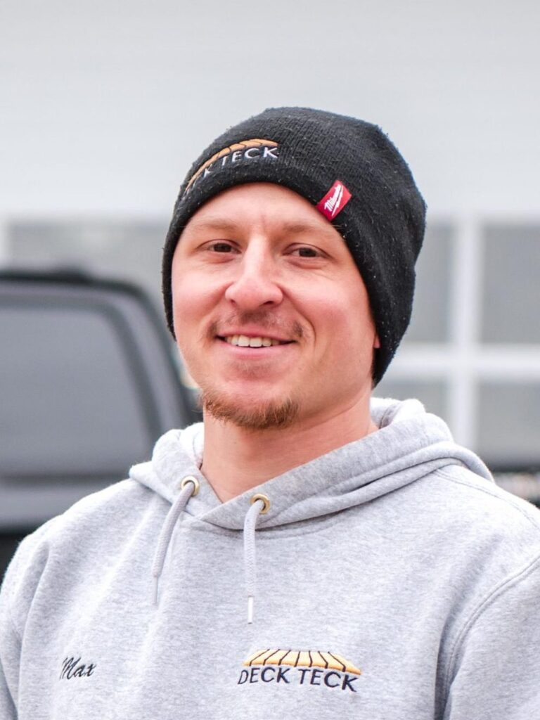 Deck Teck Owner, Max McNally, standing in front of a black company truck